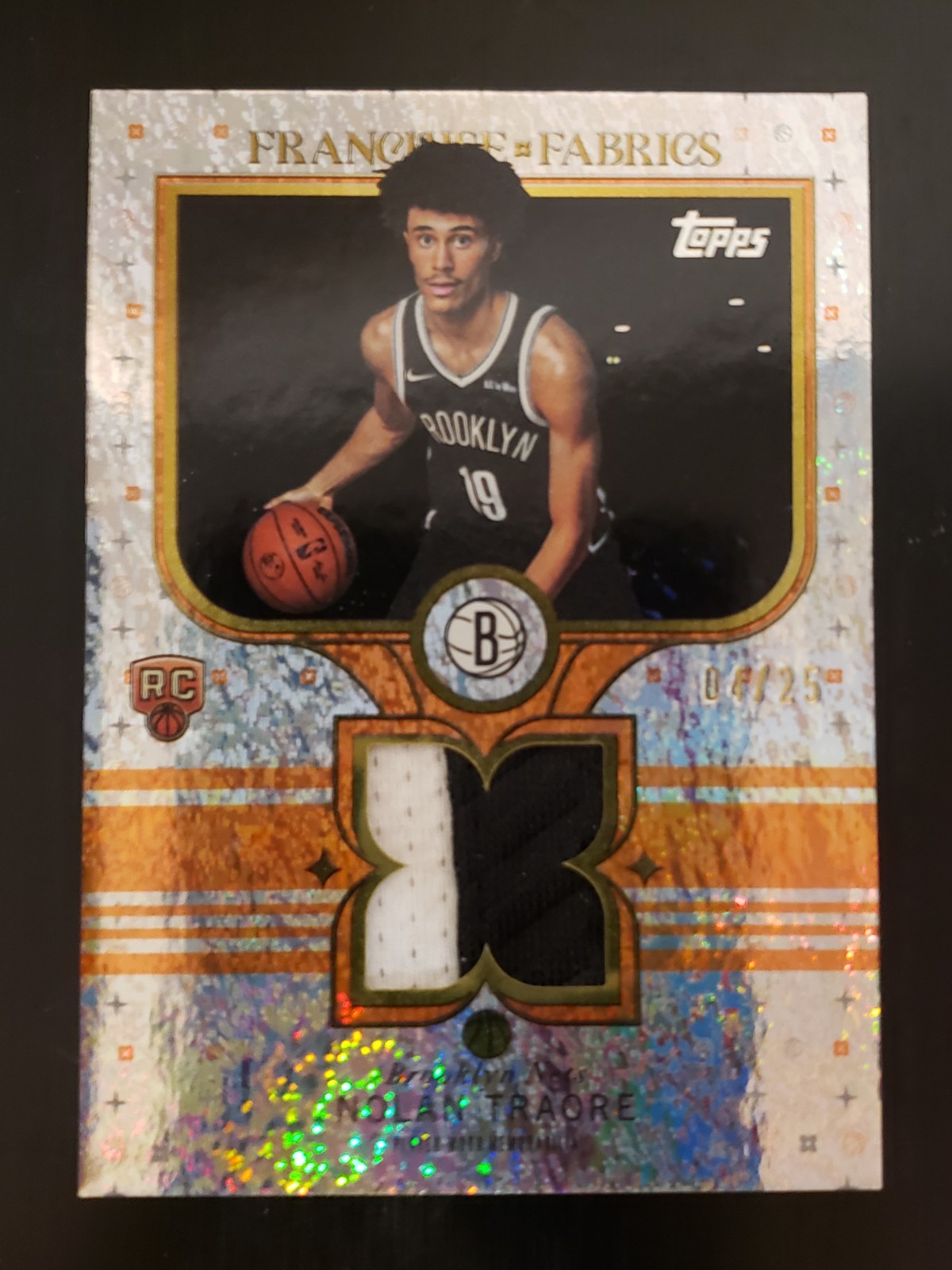 Nolan Traore 2025-26 Topps Franchise Fabrics Orange Holo Foil #/25 RC #FF-NT