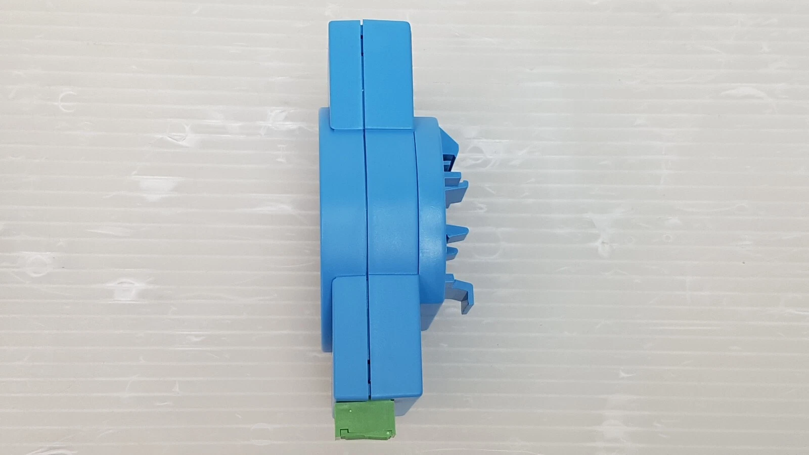 Side view of the blue ADAM-4571 housing with mounting clips and green terminal block