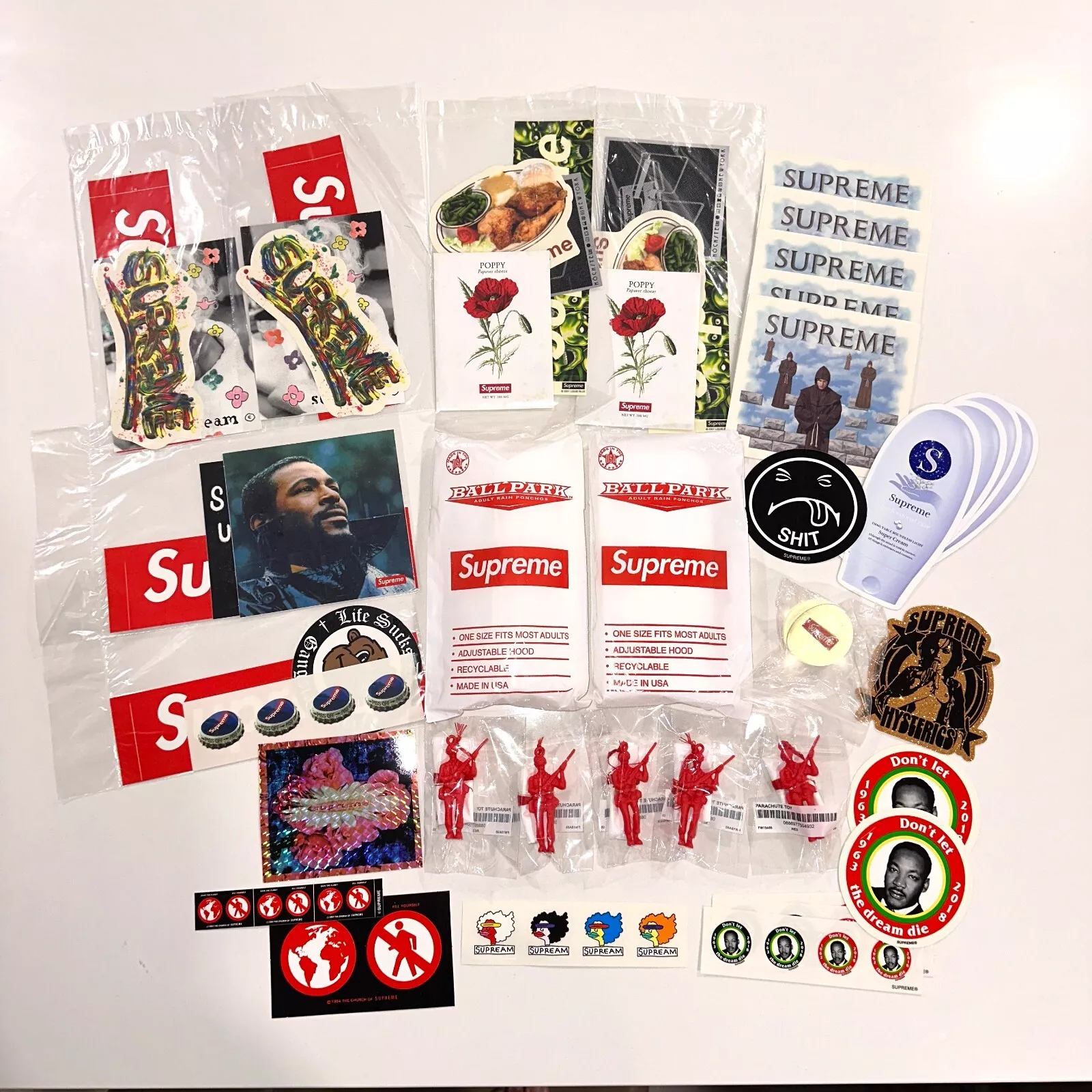 Lot d'accessoires Supreme   Ponchos, jouets parachute, boule gonflable, coquelicot, autocollants