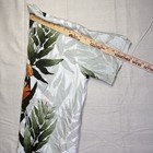 Gray vintage Wyland AFTCO Bluewater men’s Hawaiian shirt with orange and green leaf print, folded with rulers in background.