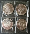 Four 1986 1oz Silver World Trade Unit Rounds in Plastic