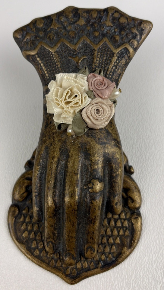 A delicate Victorian brass lady's hand paper clip and letter holder — a tiny sculptural hand emerging from floral brass work, equal parts useful and wonderfully strange.