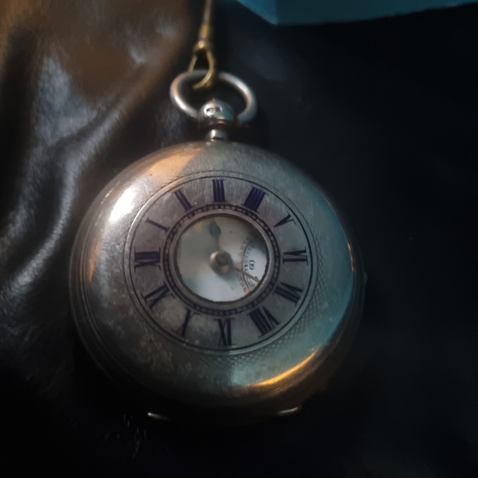 A genuine antique half-hunter silver pocket watch — the hinged cover with the cutout dial window is a Victorian design detail you just don't see anymore.