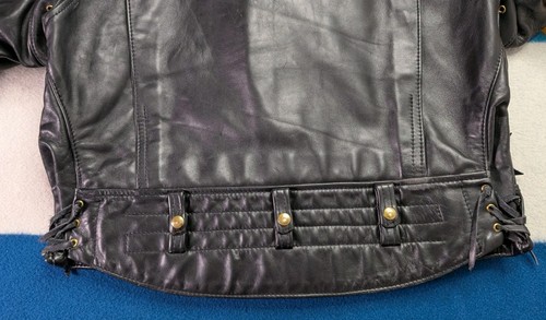 Black vintage leather Langlitz motorcycle jacket with quilted back panel, button front, and two zippered pockets.