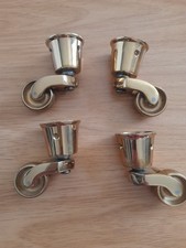 A Set Of Four Brass Table Leg Wheels