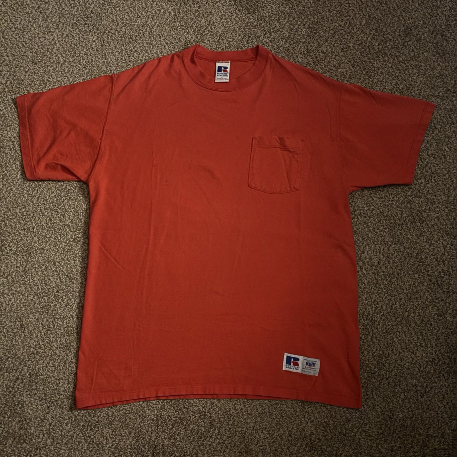 Red Russell Athletic men’s T-shirt with short sleeves, front pocket, and “Made in USA” label on left chest.