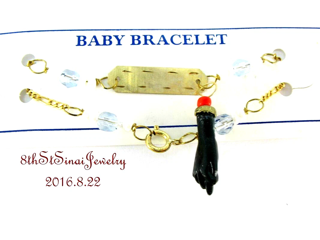 Gold baby bracelet with black best sale fist