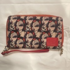 Sand One wristlet wallet featuring a repeating collage of the artist's doll