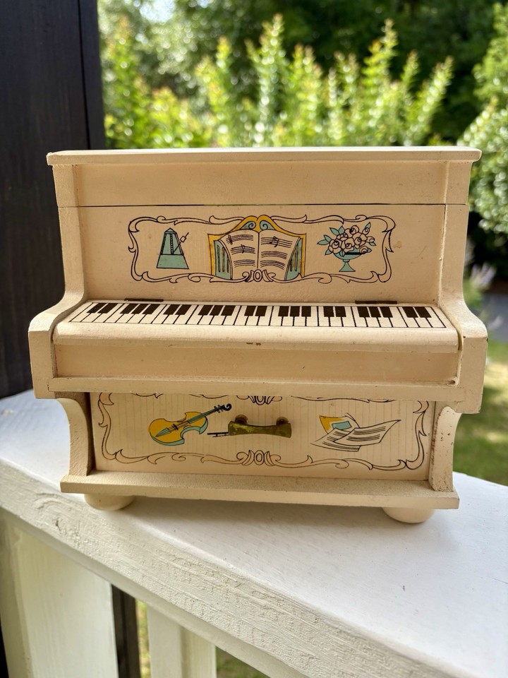 A 1970s piano-shaped jewelry box with a mirrored interior and a 'Girl with Harp' figurine — a time capsule of retro feminine design that's genuinely striking.