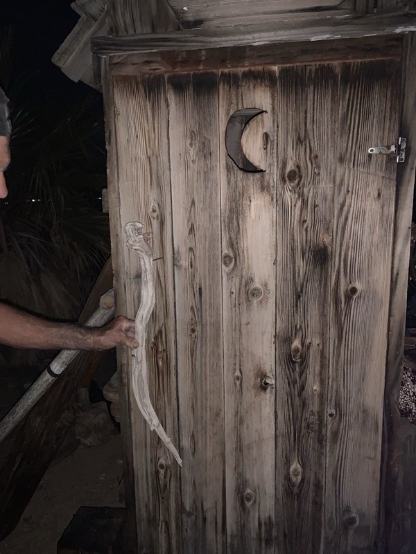 antique reclaimed wood outhouse/toolshed  with crescent moon cutout on door
