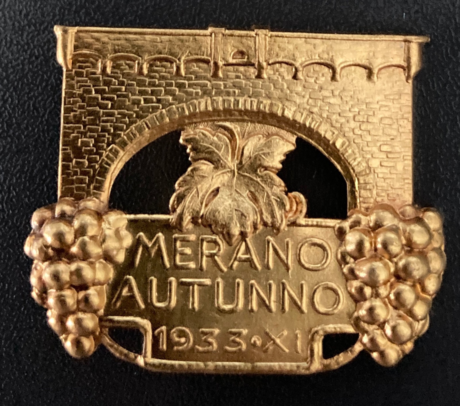Spilla in metallo MERANO AUTUNNO 1933 "Racccolta dell'uva in epoca Fascista"