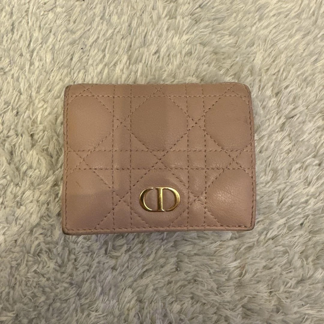Portefeuille Dior rose à deux volets occasion quelques signes d'usure numéro de série inclus