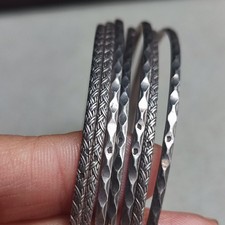 Lot de sept bracelets jonc en argent estampé, cira 1900s. TTL: 28g