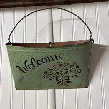 Distressed Vintage green metal wall pocket with "Welcome" and floral cut-outs.