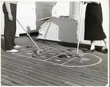Couple playing shuffleboard on deck of a ship They are shown only f- Old Photo