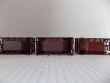 3) ORE CAR TRAIN BY ROUNDHOUSE ATTACHED BY A  DRAWBAR