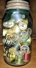 Vintage mixed colored wooden sewing thread spools &  in a large Ball jar 