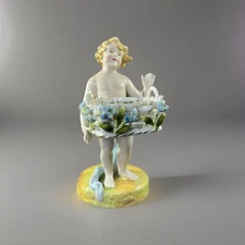old German porcelain figure cherub with basket.