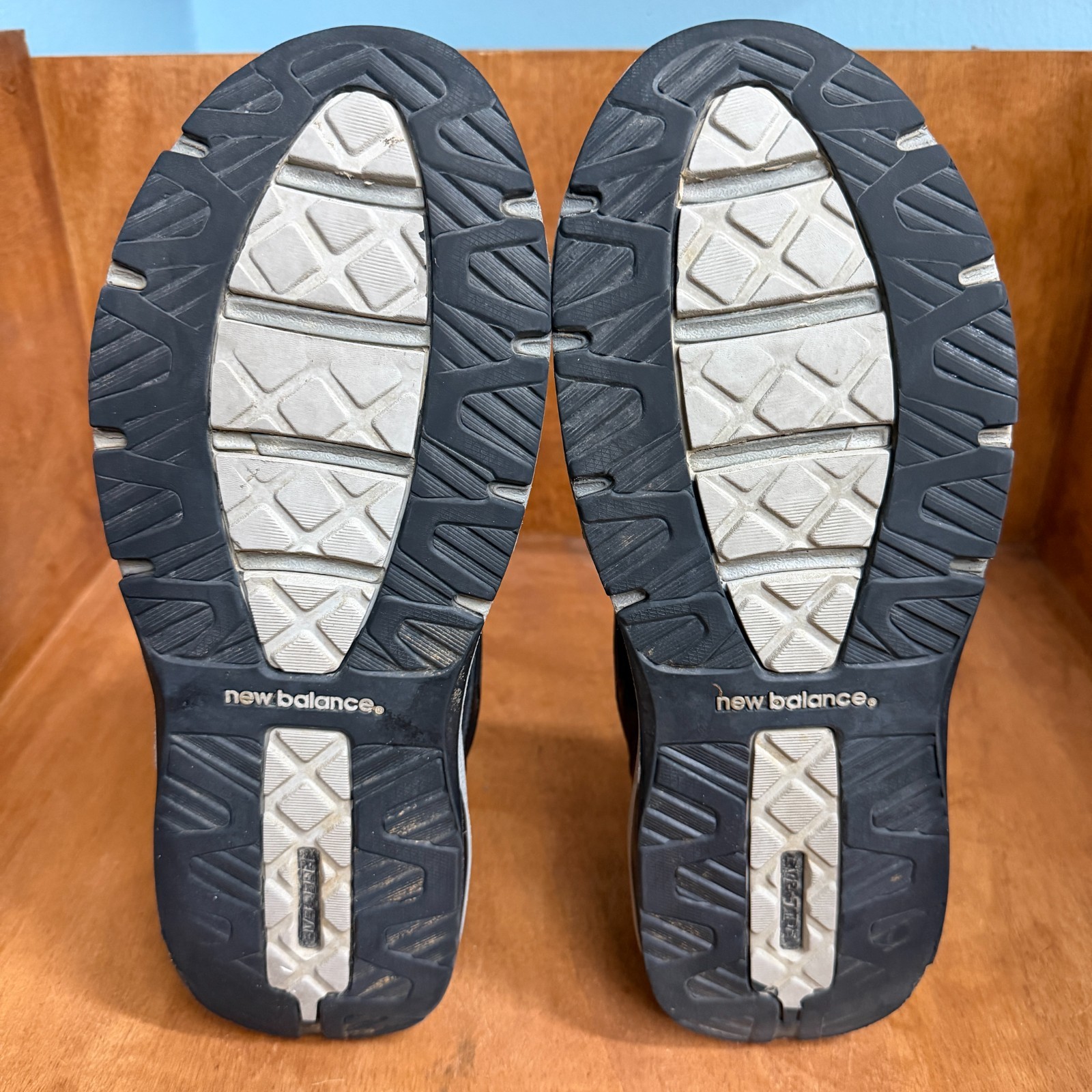 Black and gray New Balance 1540V2 running shoes with textured mesh uppers, silver soles, and visible “new balance” branding.