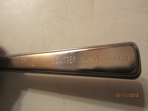 Vintage silver Playtex Hair Cutter with black handle, engraved “100% Safe-Stainfree” beside engraved “7/11/2018.”