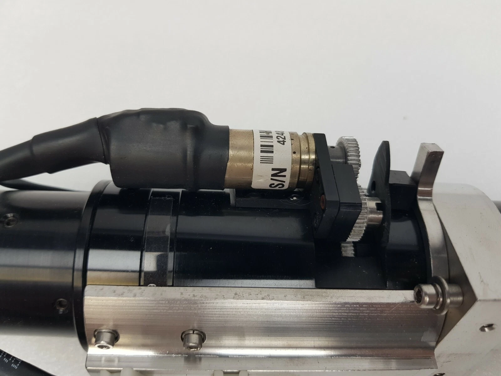 Motor with drive gear on the stainless bracket beside the Navitar zoom