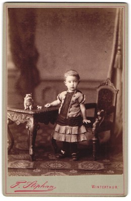 Fotografie F. Stephan, Winterthur, Kleinkind im Kleid mit Kummerbund 