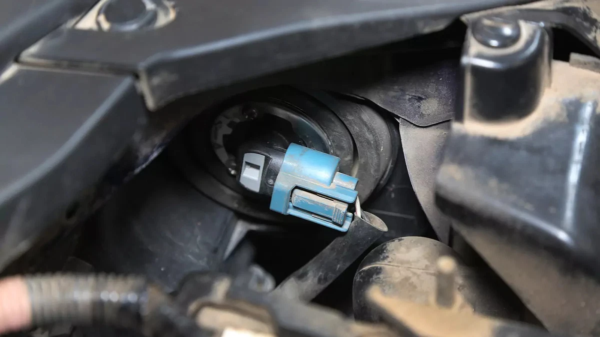 Unlocking and removing a headlight bulb to easily replace it.