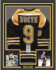 FRAMED Autographed/Signed JOHNNY BUCYK 33x42 Boston Black Hockey Jersey JSA COA