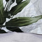 White vintage Wyland AFTCO Bluewater men’s Hawaiian shirt with green leaf pattern and navy “Wyland” text on collar.