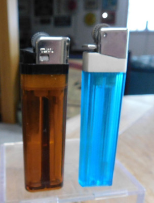 TWO VINTAGE SCRIPTO BUTANE LIGHTERS TRANSLUCENT BROWN & BLUE NOT WORKING.