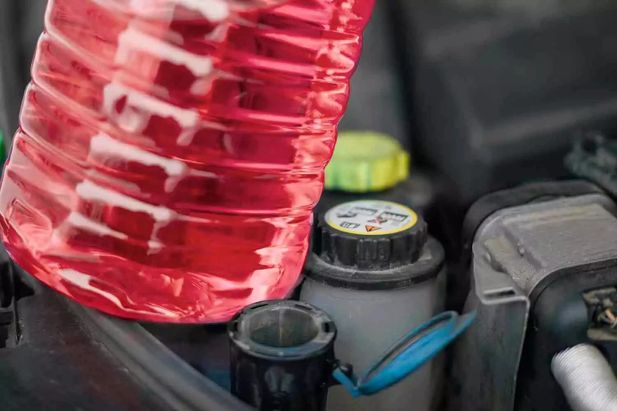 A close-up photo of a jug filled with red engine coolant.