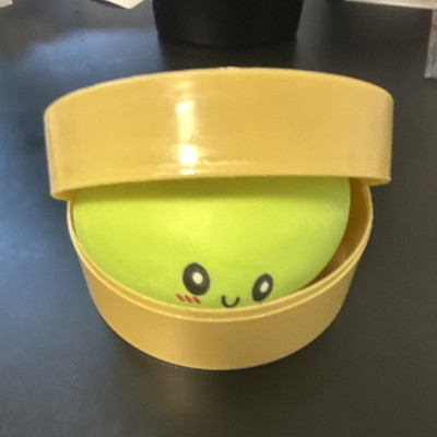 Green Foam Squeeze Ball with Cute Face Design in Yellow Container