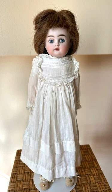 Bisque doll dressed in handmade clothes, 1890-1900