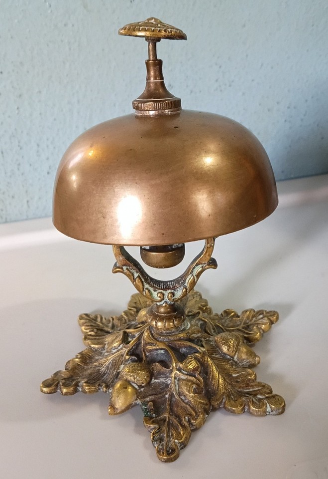 A circa-1900 antique brass hotel counter bell embossed with oak leaves and acorns — functional, gorgeous, and rings with a century of history.