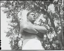 The camera looks up at Joe Louis as he strikes a majestic pose dur- Old Photo