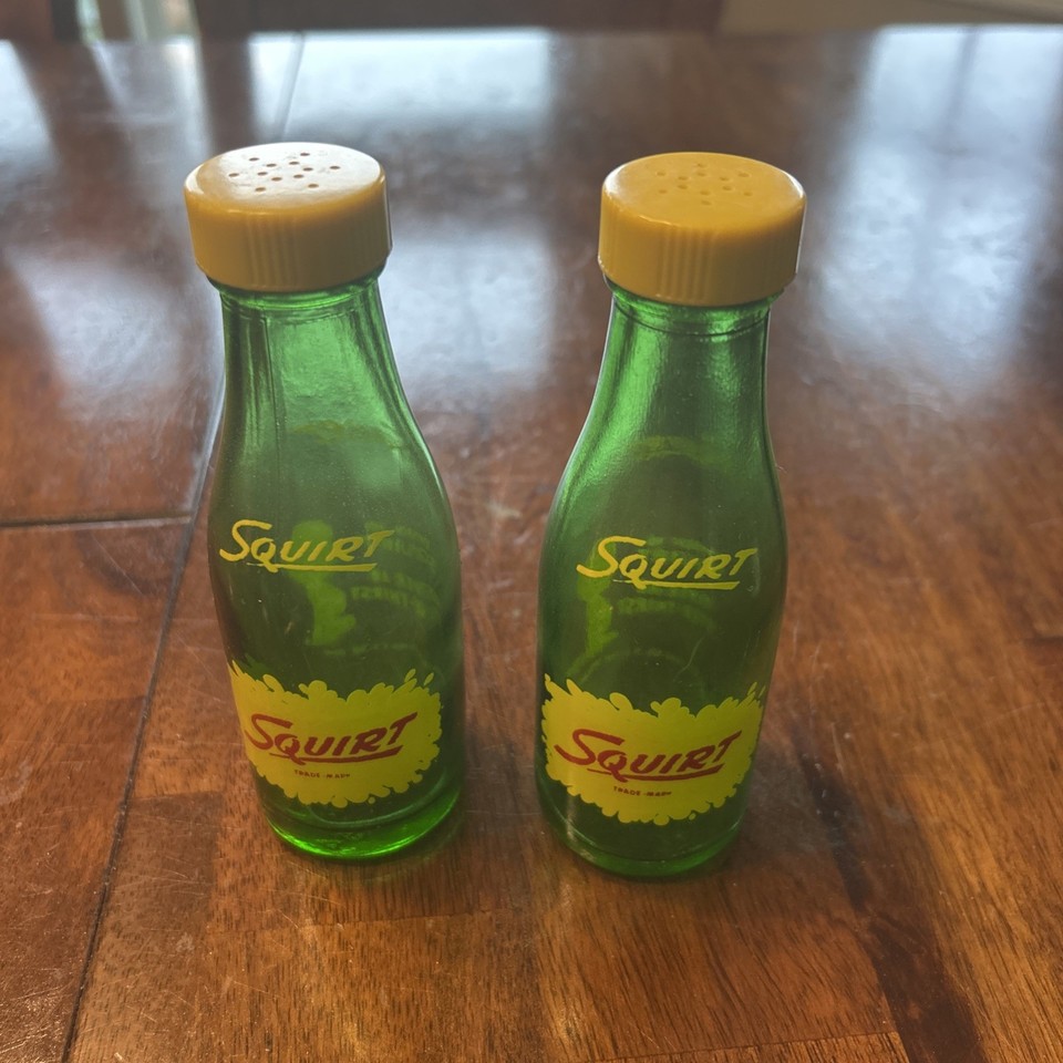 Vintage Squirt soda advertising salt & pepper shakers in green glass — classic diner-era branded collectibles that earn their spot on any kitchen shelf.
