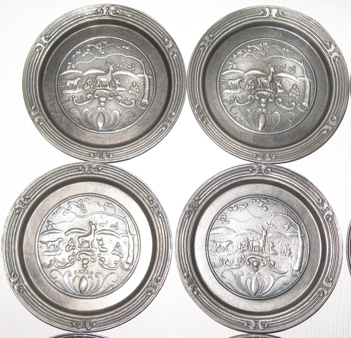 Neunteiliges Zinn-Untersetzer-Set mit detaillierten Relief-Jagdmotiven (Rehe, Ja