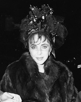Elizabeth Taylor wearing a fur coat with a ribbon lace hat as she - Old Photo