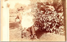 Boy in Suit Holding Baby Outdoors by Garden Plants, Snapshot RPPC Postcard