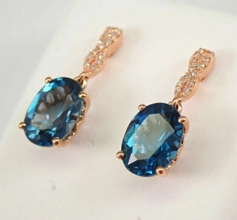 Pendientes colgantes de topacio azul Londres creados en laboratorio ovalados de 3 quilates enchapados en oro rosa de 14 quilates Foto 3 de 4