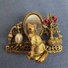 Spilla gatto vintage 1928 Co. oro con finta perla e specchio riflesso su vanità  