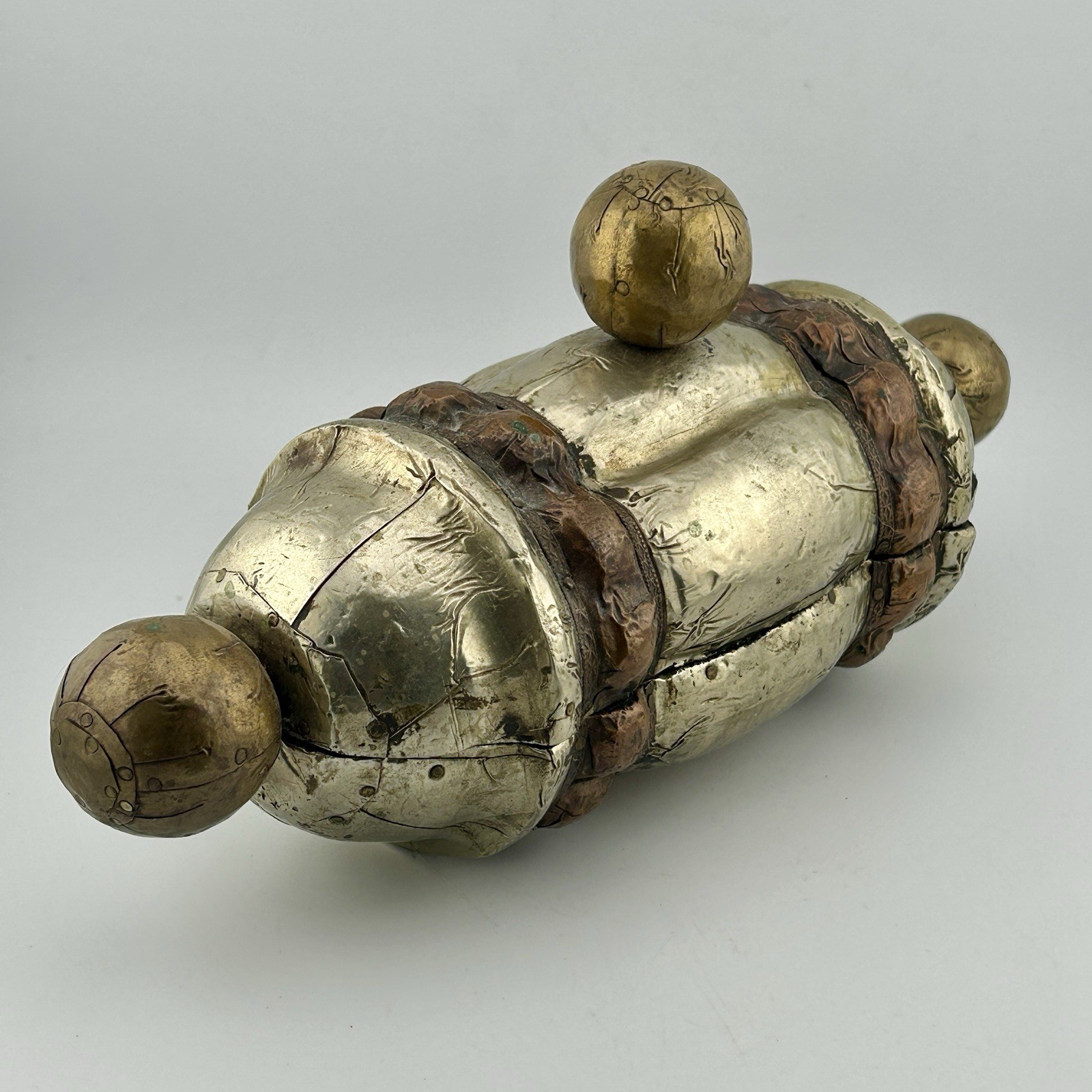 Small hinged brass and copper trinket box on a white background.