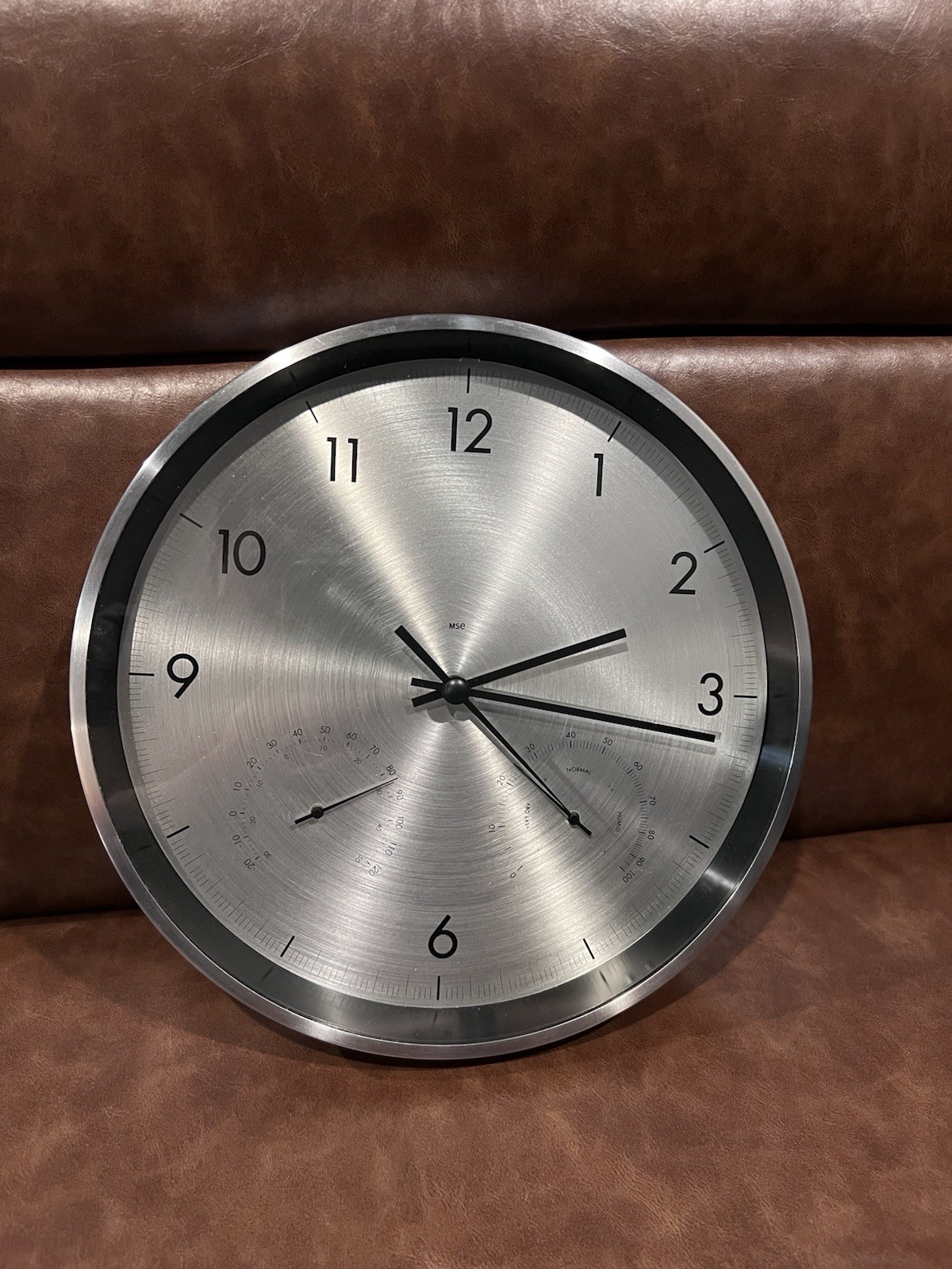 modern stainless steel wall clock with an integrated thermometer and hygrometer