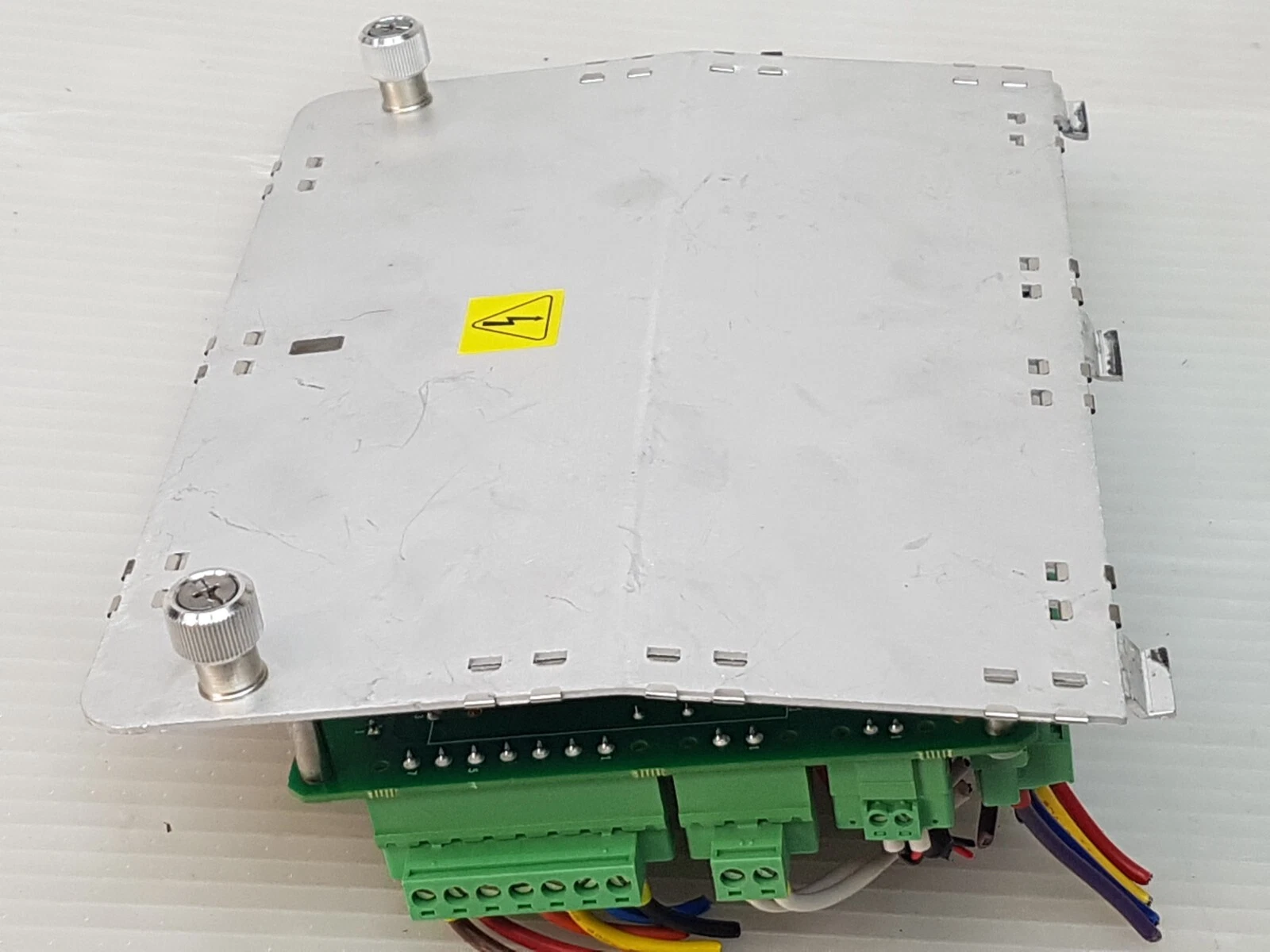 Underside of the aluminium plate with captive thumbscrews and high-voltage warning label