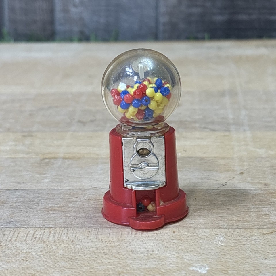 A miniature vintage gumball machine fridge magnet — maximum kitschy charm in a tiny, conversation-starting package.