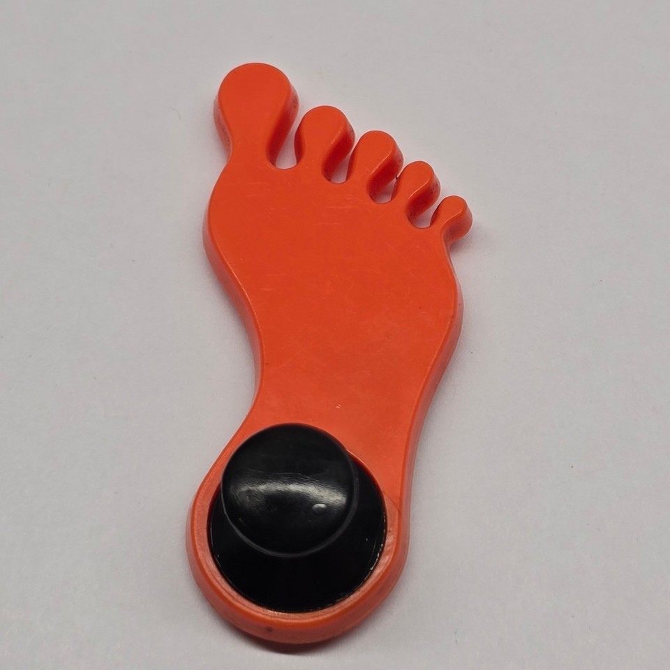 A chunky orange vintage plastic foot magnet — weird, retro, and exactly the kind of deadpan novelty object that wins every white elephant exchange.