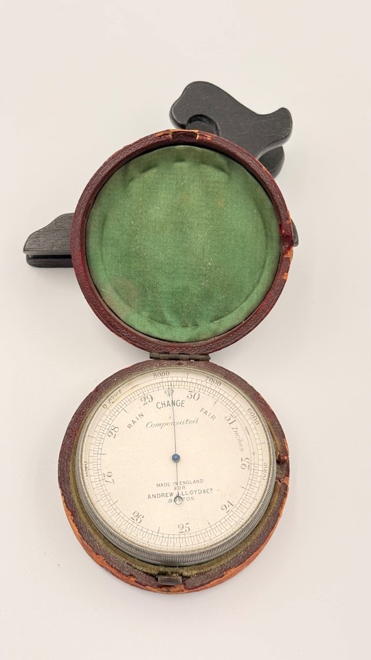 A genuine antique English pocket barometer in its original leather case — the kind of object that looks like it belongs in a Victorian explorer's kit.