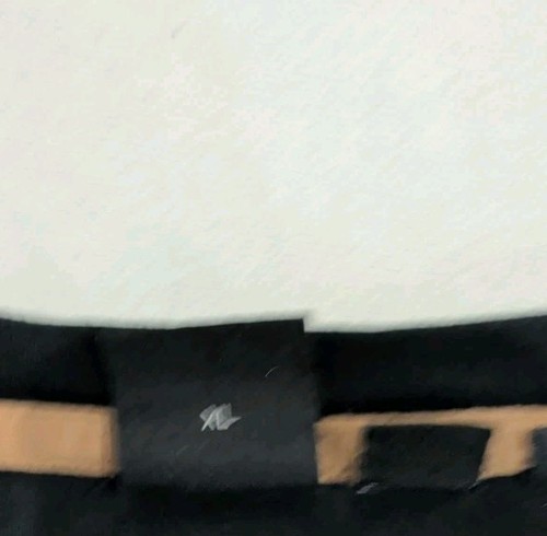 Black BOSS x Muhammad Ali T-shirt with brown leather patch, elastic waistband, and GOAT logo on white background.