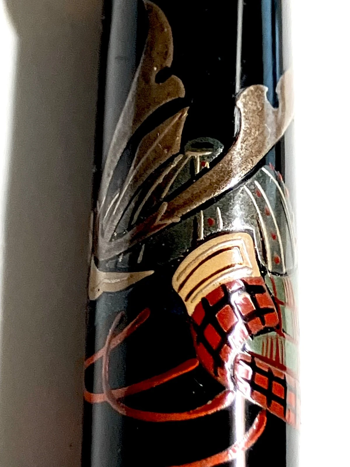 Black vintage fountain pen with ornate red and silver armor design on side, labeled “HARUYAMA made urushi makie Kabuto.”