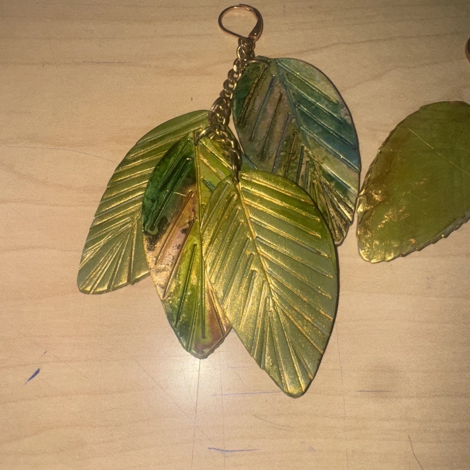 Pendientes colgantes de cuatro hojas de cuero metálicos pintados a mano Foto 2 de 3